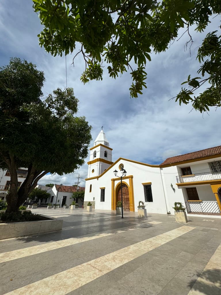 A white and yellow church on a plaza in Valledupar