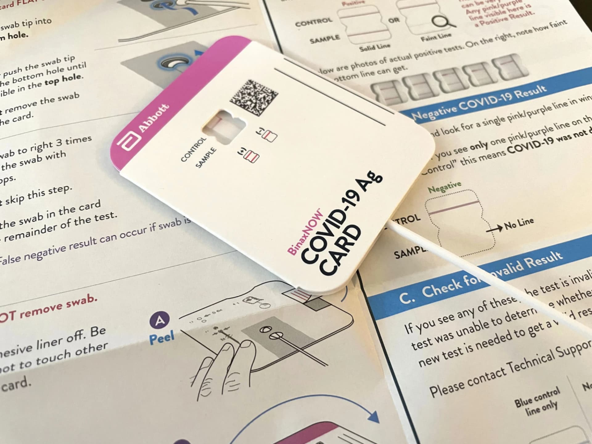 La tarjeta de prueba BinaxNOW junto a sus hojas de instrucciones impresas